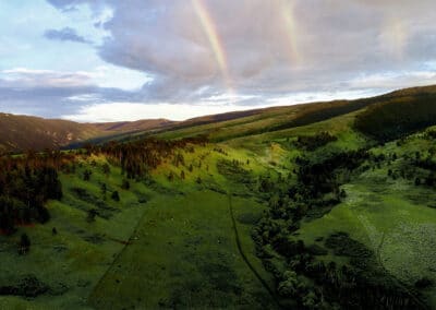 Photo of rolling green grazing land with a double rainbow in the Bighorn Mountains of northern Wyoming