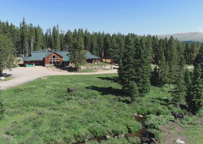 Wyoming High Country Lodge Bighorn Mountains recreation resort and moose drinking from the creek